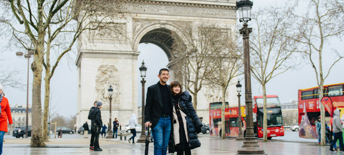 Honeymoon couple walking at champs Elysee, background Arc de Triomphe Paris. Photosession by Eny Therese Photography
